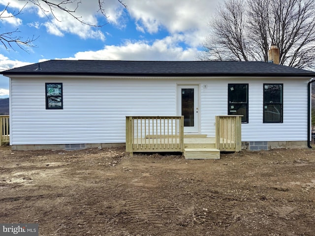 back of house featuring crawl space, a chimney, and a wooden deck