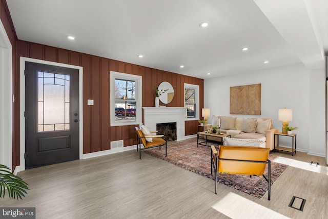 living room with recessed lighting, a brick fireplace, a healthy amount of sunlight, and light wood-style flooring