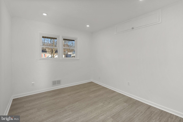 unfurnished room featuring light wood finished floors, recessed lighting, visible vents, and baseboards