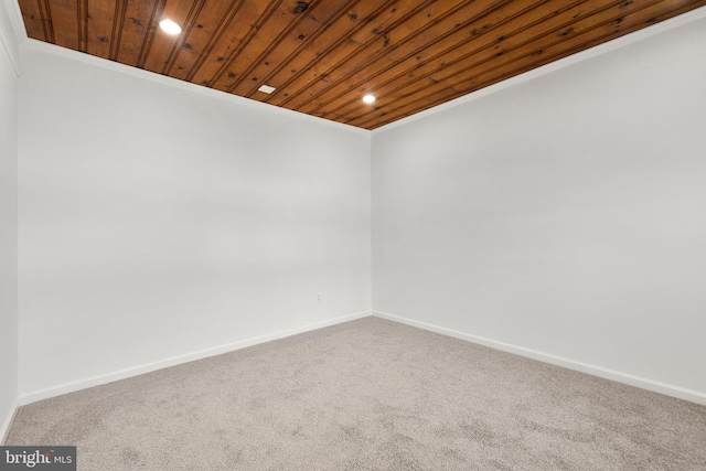 carpeted empty room with wood ceiling, baseboards, and recessed lighting