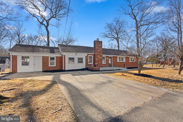 single story home featuring brick siding and a chimney