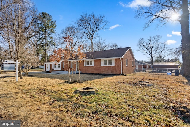 exterior space featuring a yard, a patio area, brick siding, and fence