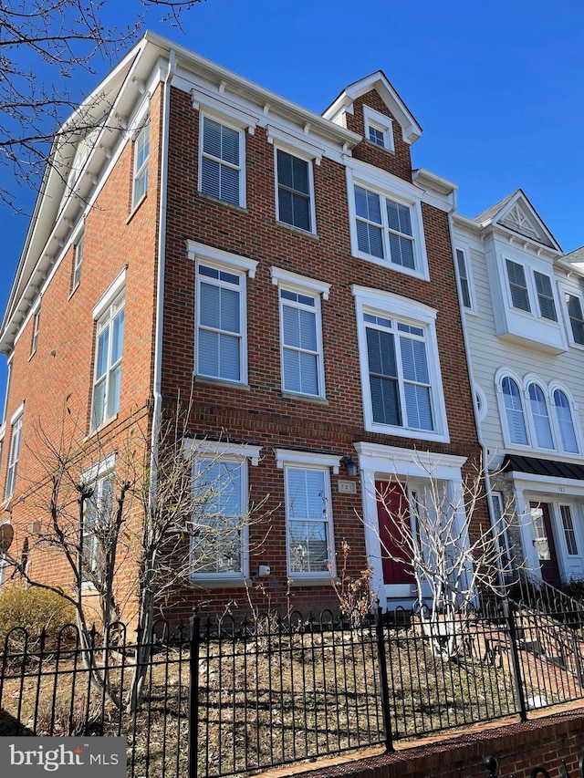 view of property featuring a fenced front yard and brick siding