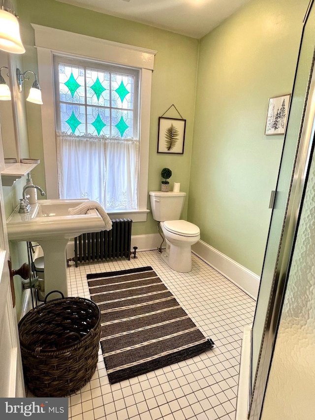 bathroom with tile patterned flooring, radiator heating unit, and toilet