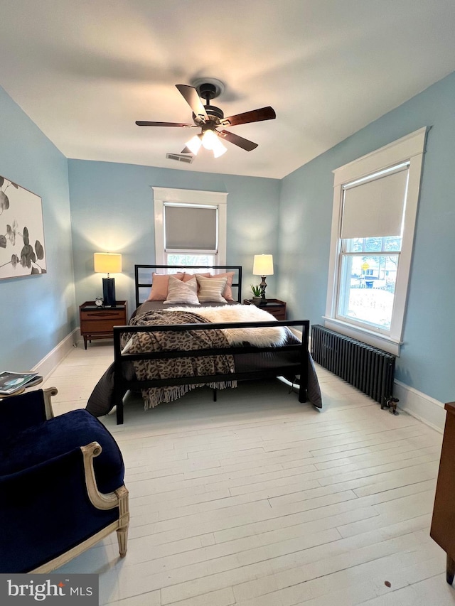 bedroom with radiator, ceiling fan, and light wood-type flooring