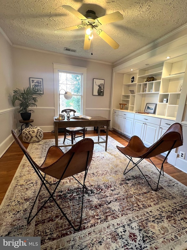 office area featuring crown molding, hardwood / wood-style floors, ceiling fan, and a textured ceiling