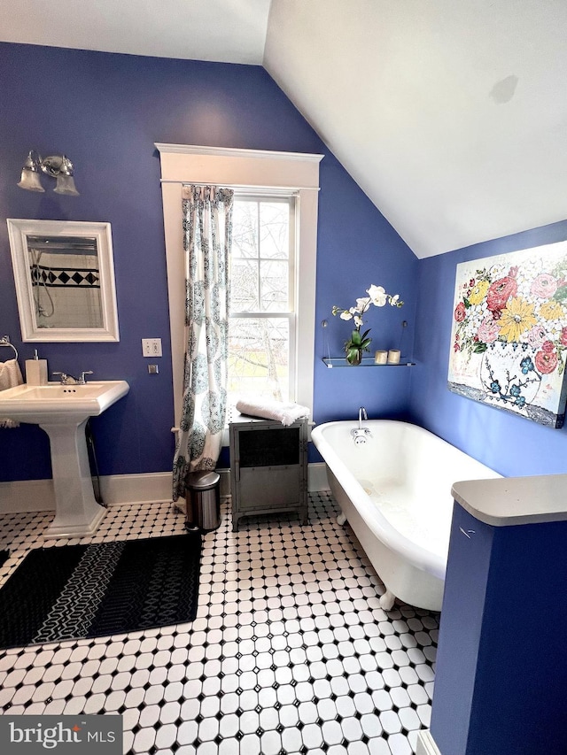 bathroom featuring vaulted ceiling, sink, and a bathtub