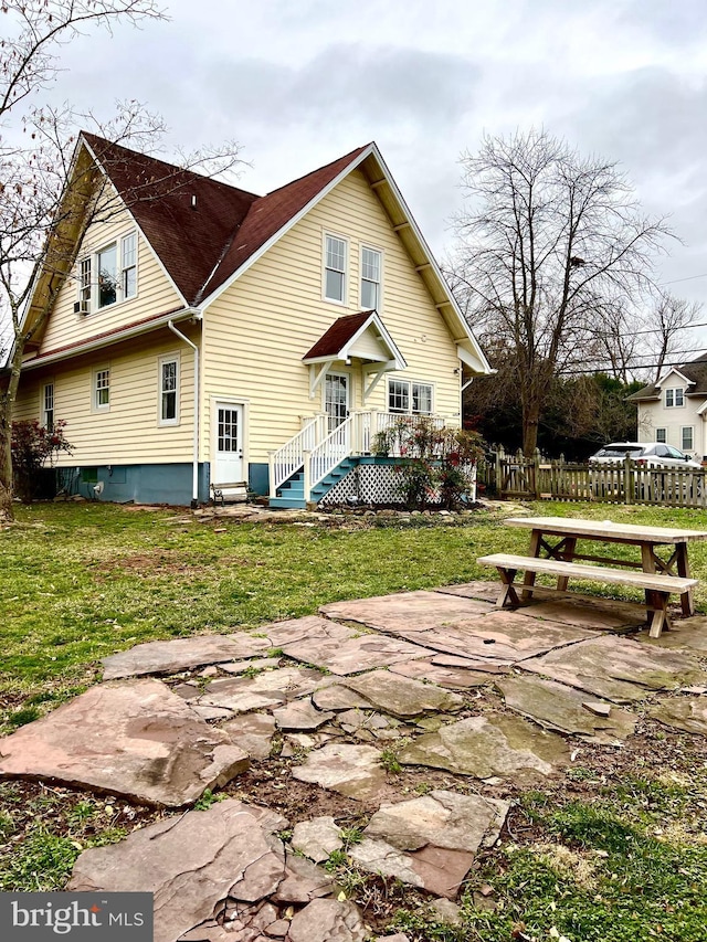 rear view of property featuring a patio and a yard