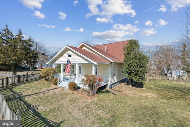 bungalow-style house with a front yard and covered porch