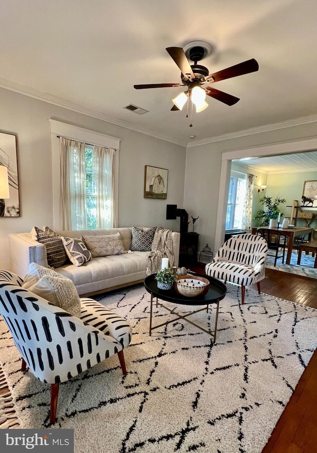 living room featuring crown molding, a healthy amount of sunlight, and hardwood / wood-style floors