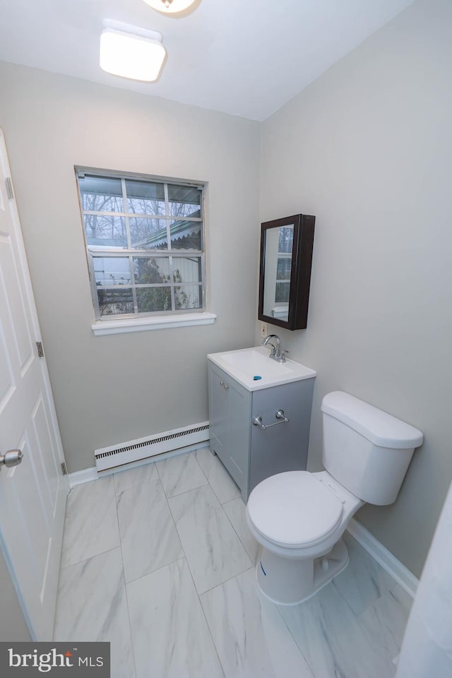 bathroom featuring baseboard heating, vanity, and toilet