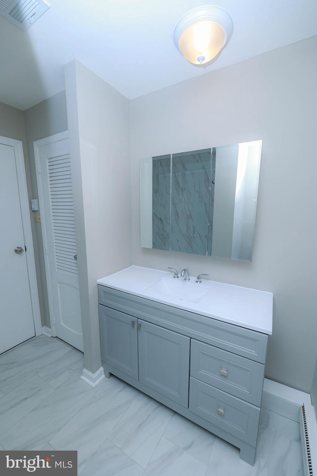 bathroom featuring baseboards, visible vents, marble finish floor, vanity, and a baseboard heating unit