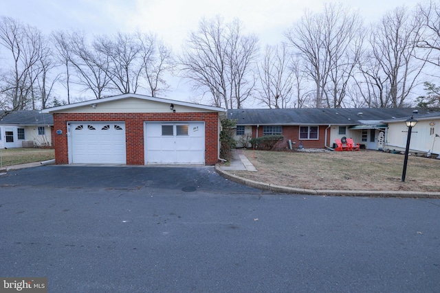 ranch-style house featuring a garage and brick siding