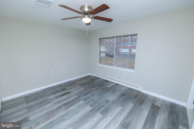 empty room with a baseboard heating unit, hardwood / wood-style flooring, and ceiling fan