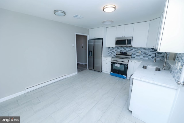 kitchen with tasteful backsplash, white cabinets, appliances with stainless steel finishes, a baseboard heating unit, and a sink