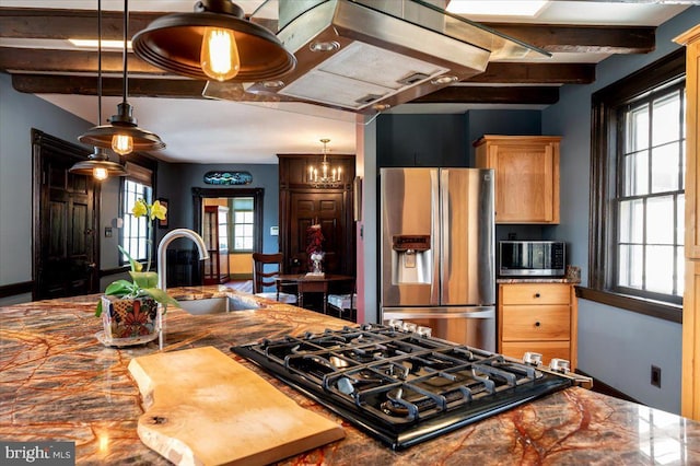 kitchen with appliances with stainless steel finishes, beamed ceiling, a sink, and pendant lighting