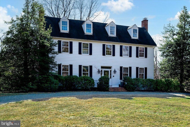 view of front of property with a chimney and a front yard