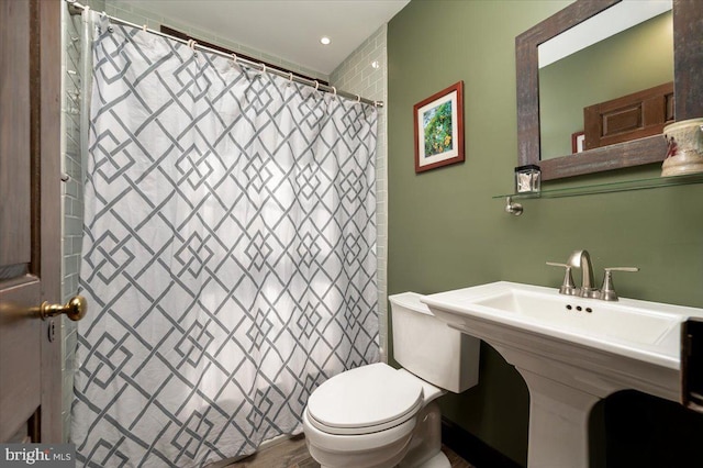 full bath featuring toilet, a sink, and a shower with shower curtain