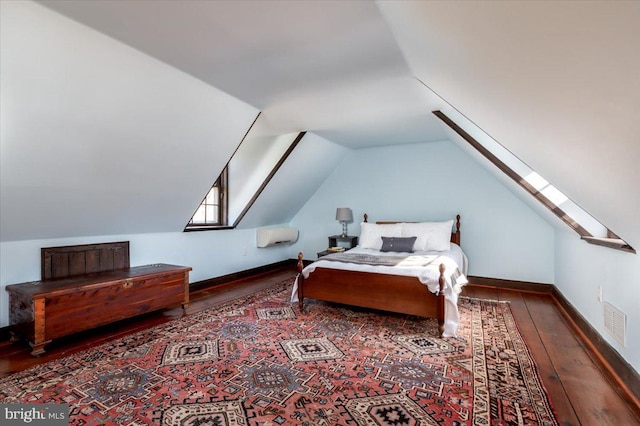 bedroom with vaulted ceiling with skylight, visible vents, baseboards, and hardwood / wood-style flooring