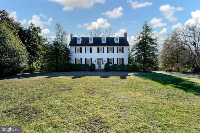 view of front of property featuring a chimney and a front yard