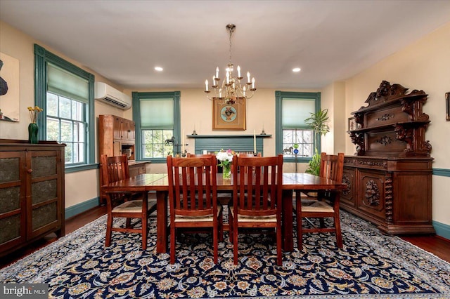 dining area featuring a wall unit AC, baseboards, wood finished floors, and recessed lighting