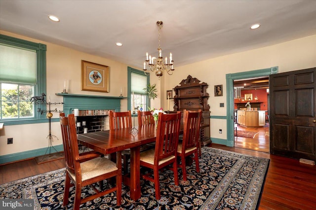 dining room with baseboards, hardwood / wood-style flooring, and an inviting chandelier