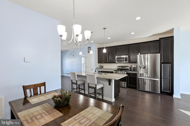 dining room featuring sink, dark hardwood / wood-style floors, and an inviting chandelier