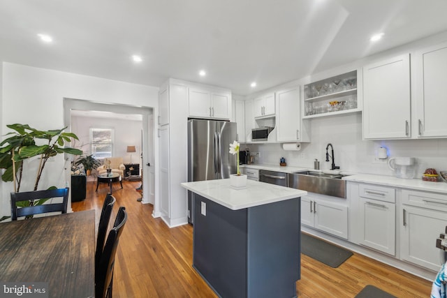 kitchen with white cabinets, a center island, and sink