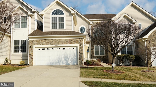 view of property with a garage and a front yard