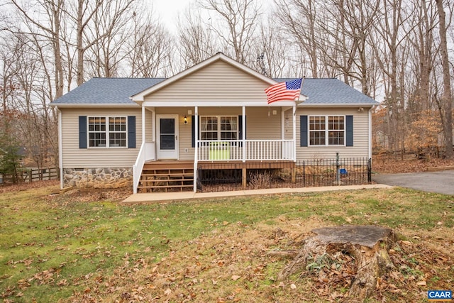 view of front of house with roof with shingles, a porch, crawl space, and a front lawn