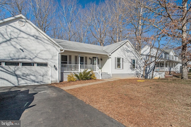 single story home with driveway, a porch, a front lawn, and an attached garage