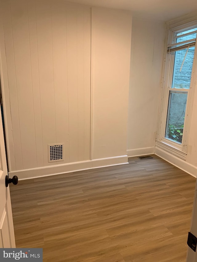 unfurnished room featuring dark hardwood / wood-style floors and a wealth of natural light