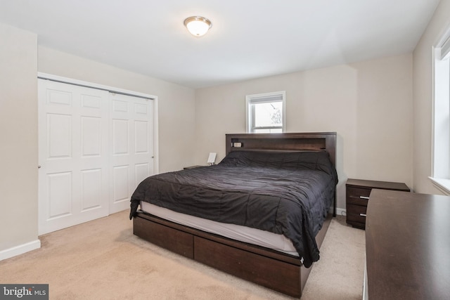 bedroom with light colored carpet and a closet