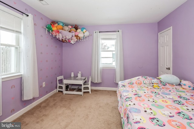 carpeted bedroom featuring multiple windows