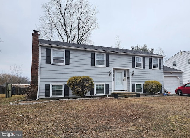 split foyer home featuring a garage and a front lawn