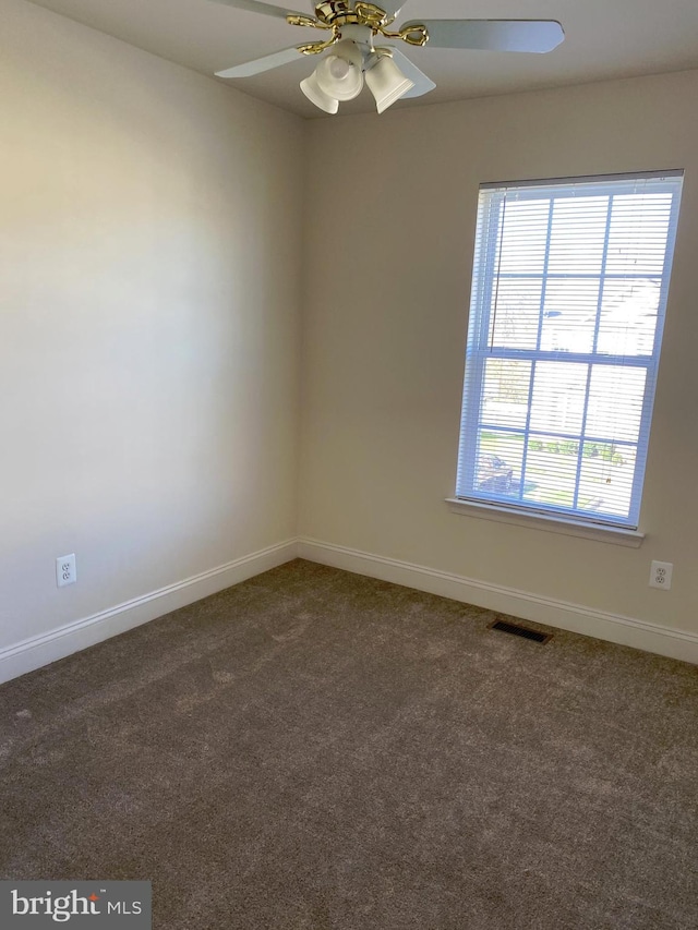 unfurnished room with ceiling fan and dark colored carpet