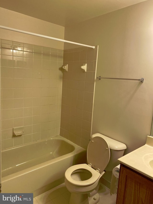 full bathroom featuring tile patterned floors, toilet, tiled shower / bath combo, and vanity