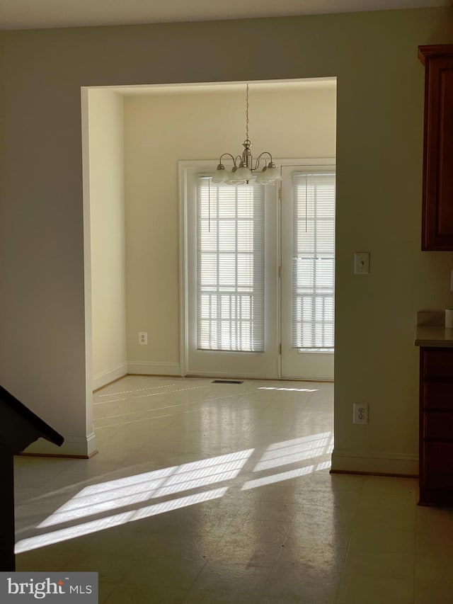 unfurnished dining area with a chandelier