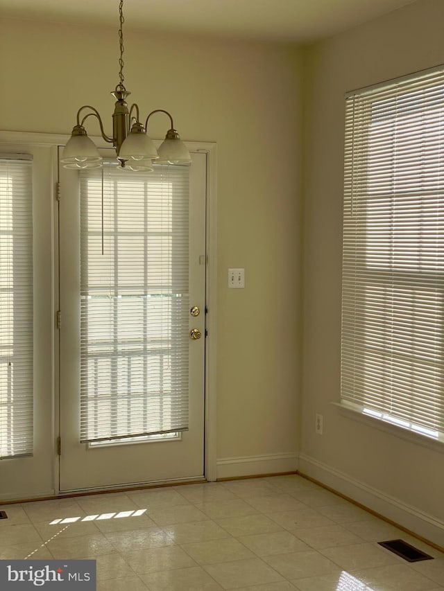 entryway featuring light tile patterned floors and a chandelier