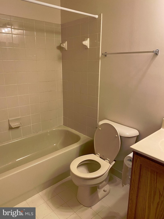 full bathroom with tiled shower / bath, vanity, tile patterned floors, and toilet