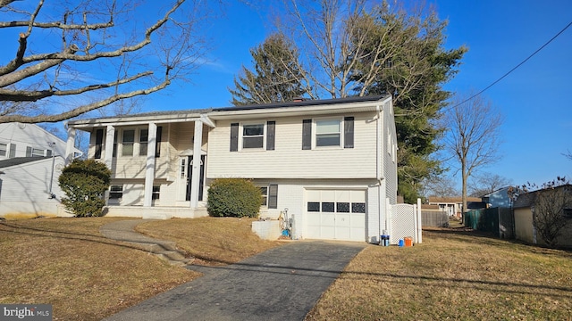 bi-level home with a garage, a front lawn, and covered porch