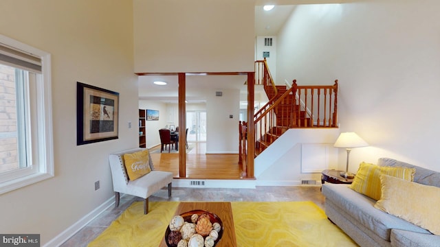 living room with a towering ceiling and light hardwood / wood-style floors