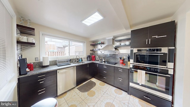 kitchen with sink, light tile patterned floors, stainless steel appliances, island range hood, and decorative backsplash