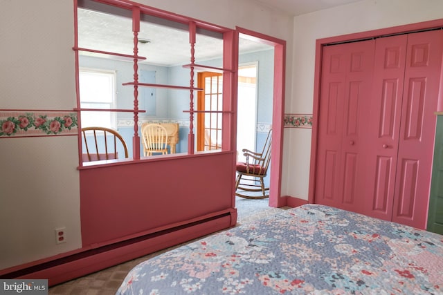 bedroom with baseboard heating, a closet, and wallpapered walls