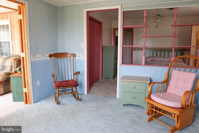 sitting room featuring carpet floors, ornamental molding, and wallpapered walls