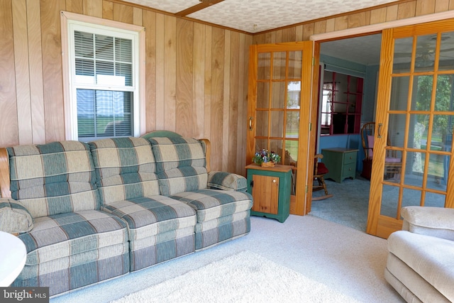 living room featuring ornamental molding, carpet, and wooden walls