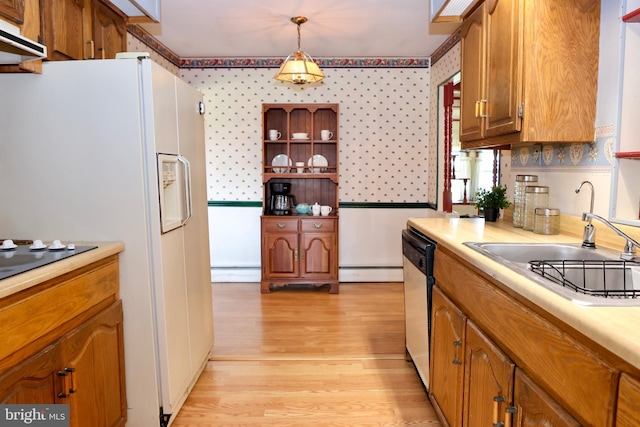 kitchen with pendant lighting, brown cabinets, light countertops, dishwasher, and wallpapered walls