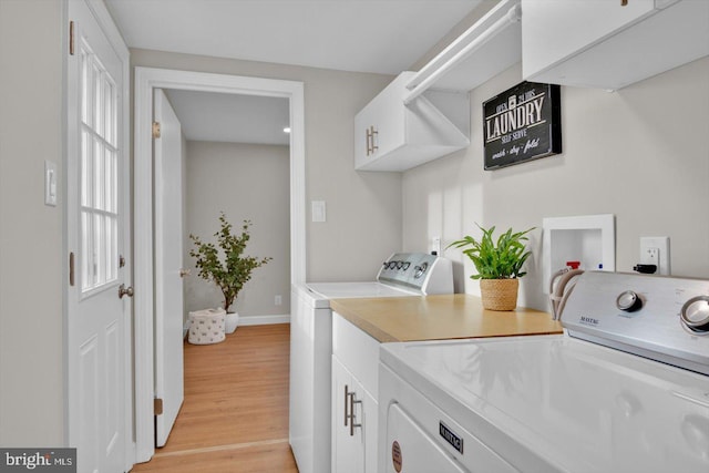 washroom with cabinets, washer and clothes dryer, and light wood-type flooring