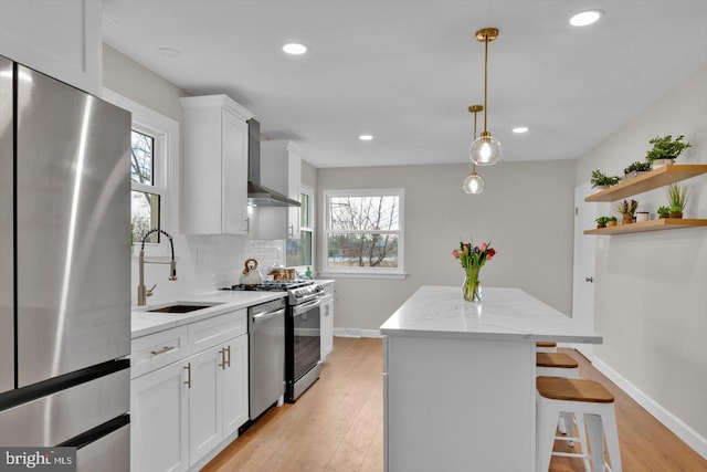 kitchen featuring sink, stainless steel fridge, wall chimney exhaust hood, and white cabinets