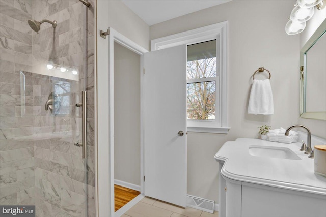 bathroom featuring tiled shower, vanity, and tile patterned floors